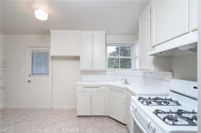 2124 Rutgers Ave, Long Beach, CA 90815 - kitchen featuring white gas range oven, tile countertops, under cabinet range hood, and white cabinetry