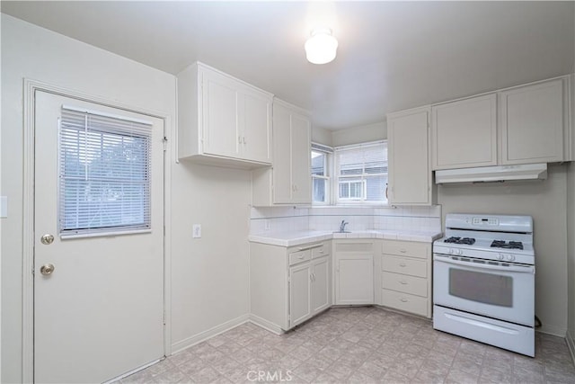 2124 Rutgers Ave, Long Beach, CA 90815 - kitchen with white gas range oven, under cabinet range hood, white cabinets, tile countertops, and tasteful backsplash