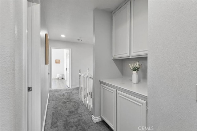 12725 Sundown Rd, Victorville, CA 92392 - hallway with dark colored carpet, an upstairs landing, recessed lighting, and a textured wall