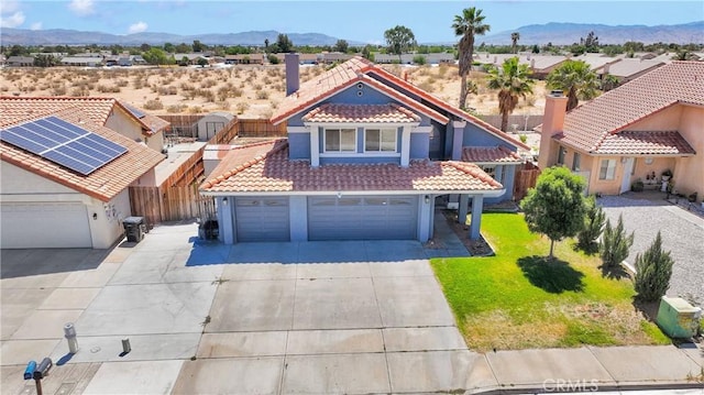 12725 Sundown Rd, Victorville, CA 92392 - view of front of home with a tile roof, a mountain view, concrete driveway, stucco siding, and an attached garage