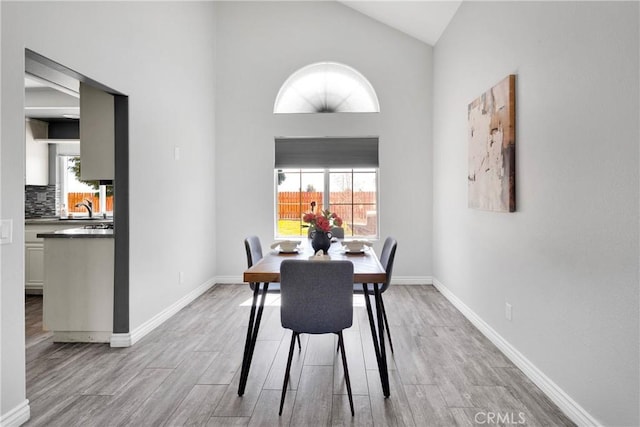 12725 Sundown Rd, Victorville, CA 92392 - dining room featuring healthy amount of natural light, high vaulted ceiling, and wood finished floors
