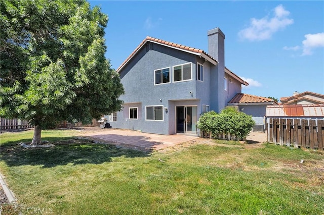 12725 Sundown Rd, Victorville, CA 92392 - back of property with a chimney, a fenced backyard, stucco siding, a tile roof, and a patio area