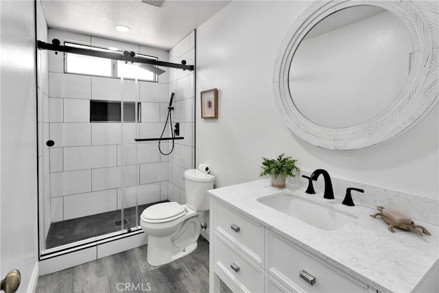 12725 Sundown Rd, Victorville, CA 92392 - bathroom featuring vanity, a shower stall, wood finished floors, and a textured ceiling