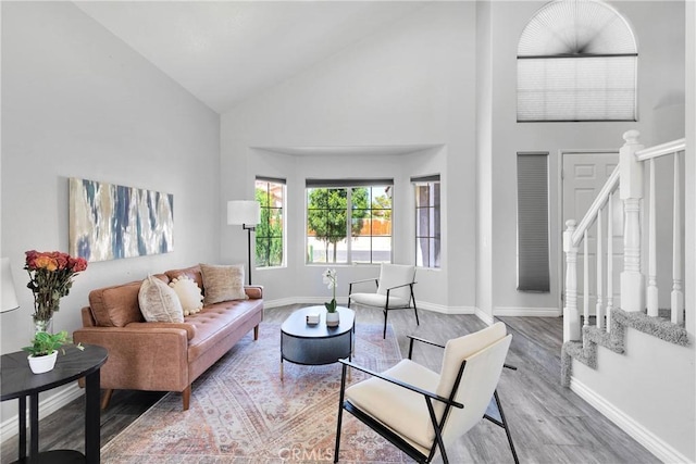 12725 Sundown Rd, Victorville, CA 92392 - living room featuring high vaulted ceiling, wood finished floors, and stairway