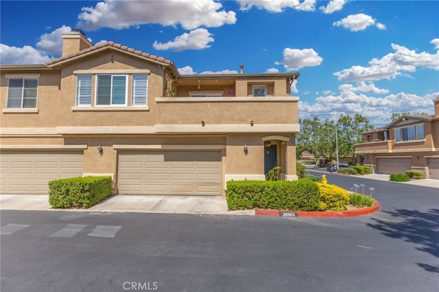 39903 Millbrook Way Unit 7C, Murrieta, CA 92563 - multi unit property featuring stucco siding, a chimney, a garage, and driveway
