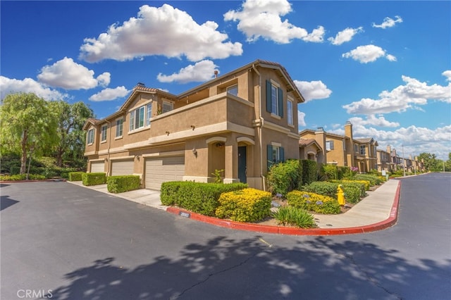 39903 Millbrook Way Unit 7C, Murrieta, CA 92563 - view of building exterior featuring an attached garage, a residential view, and driveway
