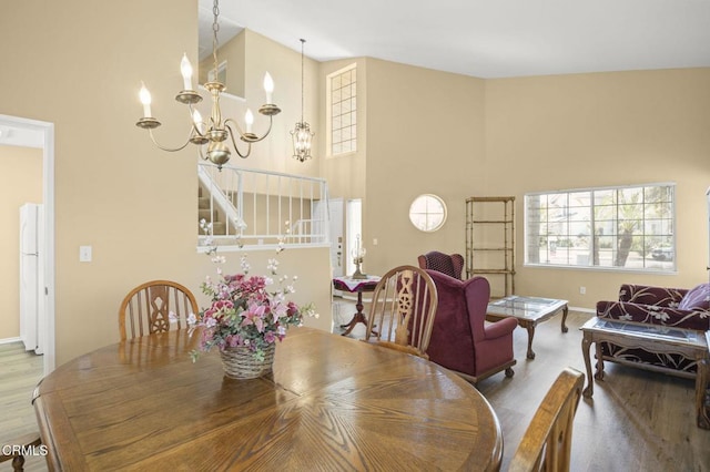 2085 Koala Pl, Oxnard, CA 93036 - dining room featuring wood finished floors, a chandelier, a towering ceiling, and stairway