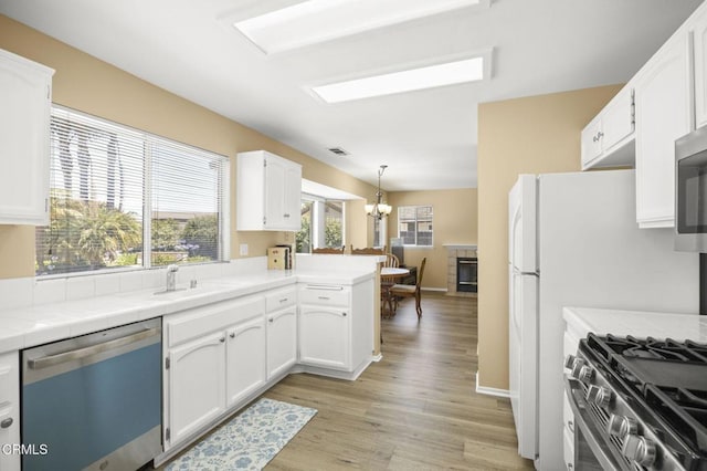 2085 Koala Pl, Oxnard, CA 93036 - kitchen featuring dishwasher, tile countertops, white cabinetry, light wood finished floors, and a chandelier