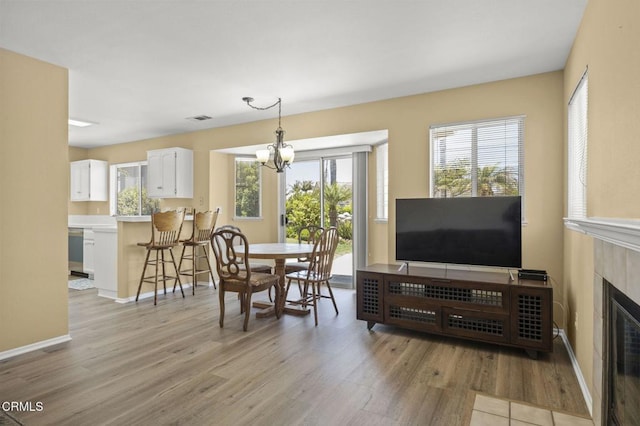 2085 Koala Pl, Oxnard, CA 93036 - dining room with light wood-type flooring, a chandelier, and a fireplace