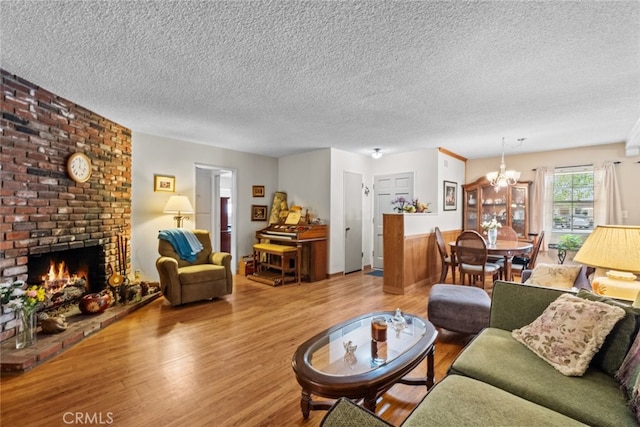 21041 Lanark St, Canoga Park, CA 91304 - living area with a chandelier, a textured ceiling, wood finished floors, and a brick fireplace