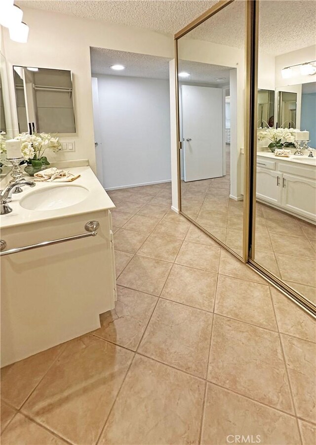3525 Bahia Blanca W Unit B, Laguna Woods, CA 92637 - bathroom featuring a textured ceiling, two vanities, and tile patterned floors