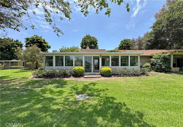 3525 Bahia Blanca W Unit B, Laguna Woods, CA 92637 - rear view of house with a sunroom, a chimney, and a yard