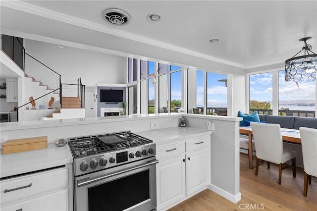 329 Travis Dr, Los Osos, CA 93402 - kitchen featuring high end stainless steel range, crown molding, open floor plan, light countertops, and white cabinetry