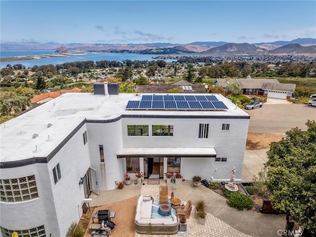 329 Travis Dr, Los Osos, CA 93402 - view of front of home with solar panels, a patio, stucco siding, and a water and mountain view