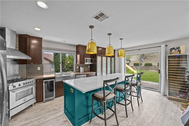 2504 Martingail Dr, Covina, CA 91724 - kitchen featuring wine cooler, appliances with stainless steel finishes, wall chimney exhaust hood, plenty of natural light, and recessed lighting