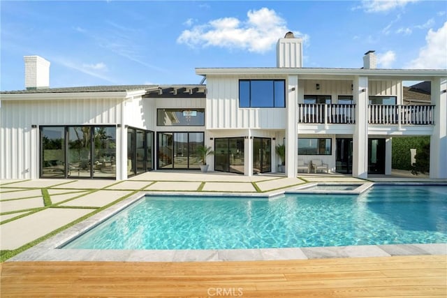 32075 Canterhill Pl, Westlake Village, CA 91361 - rear view of property featuring a balcony, a chimney, a patio, a pool with connected hot tub, and board and batten siding