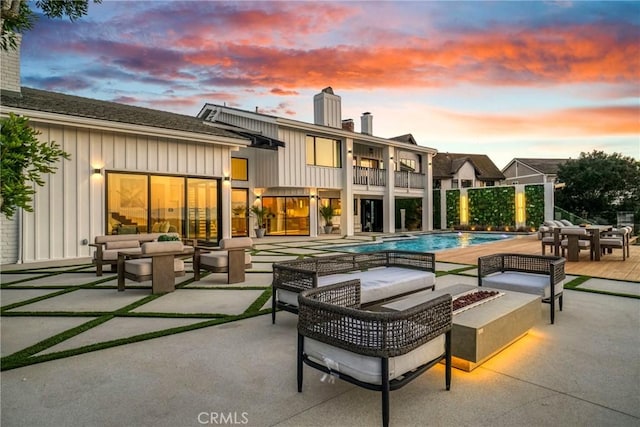 32075 Canterhill Pl, Westlake Village, CA 91361 - back of property at dusk with an outdoor living space with a fire pit, a chimney, a balcony, and board and batten siding