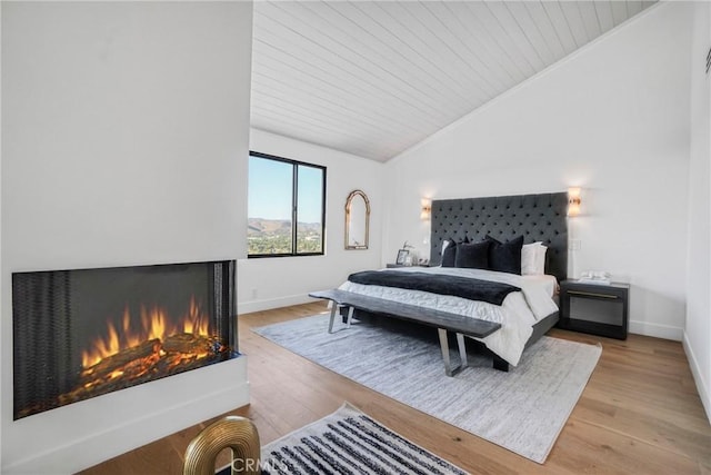 32075 Canterhill Pl, Westlake Village, CA 91361 - bedroom with vaulted ceiling, a lit fireplace, wooden ceiling, and light wood-style flooring