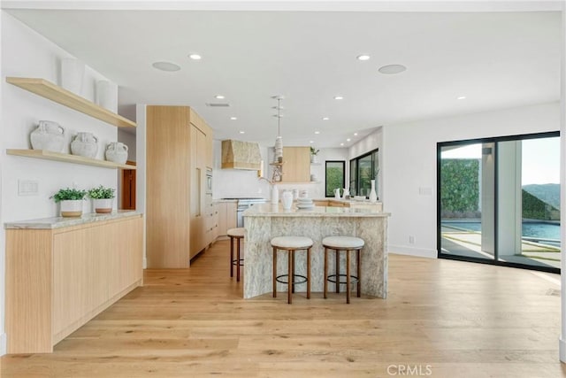 32075 Canterhill Pl, Westlake Village, CA 91361 - kitchen with light brown cabinets, light wood-style floors, modern cabinets, a breakfast bar, and a spacious island