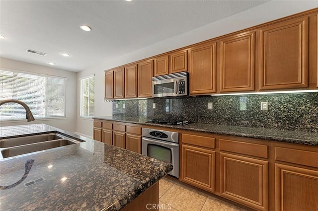 29184 Stone Ridge St, Menifee, CA 92584 - kitchen featuring stainless steel appliances, brown cabinetry, decorative backsplash, recessed lighting, and light tile patterned flooring
