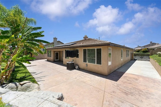 29184 Stone Ridge St, Menifee, CA 92584 - back of house with a fenced backyard, stucco siding, a patio area, solar panels, and a chimney