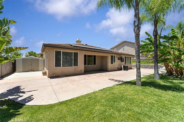 29184 Stone Ridge St, Menifee, CA 92584 - rear view of property with a storage unit, a patio area, roof mounted solar panels, stucco siding, and a fenced backyard