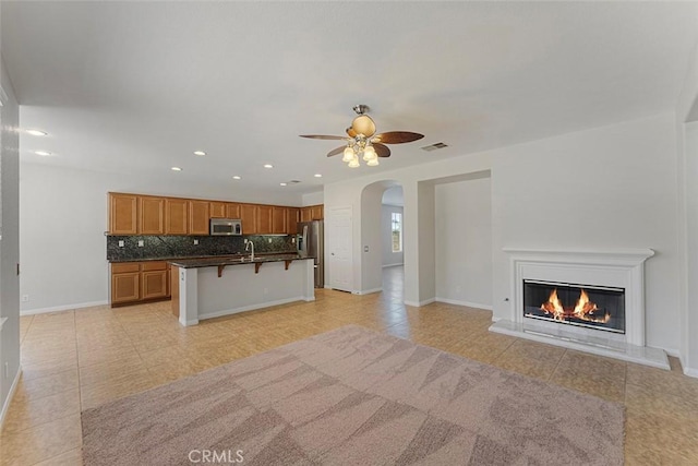 29184 Stone Ridge St, Menifee, CA 92584 - kitchen featuring appliances with stainless steel finishes, open floor plan, dark countertops, ceiling fan, and recessed lighting