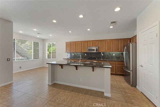 29184 Stone Ridge St, Menifee, CA 92584 - kitchen featuring stainless steel appliances, light tile patterned floors, brown cabinetry, decorative backsplash, and recessed lighting