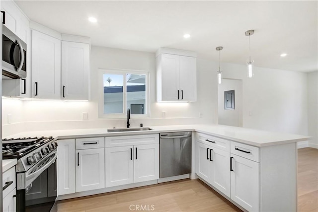 4561 Beverly Ct, Riverside, CA 92506 - kitchen with stainless steel appliances, a peninsula, light wood-style flooring, white cabinets, and light countertops