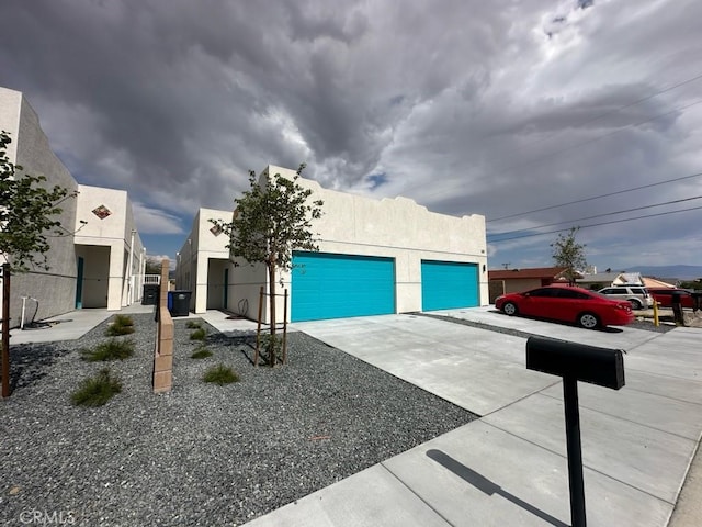 13236 El Rio Ln, Desert Hot Springs, CA 92240 - view of front of home featuring a garage, driveway, and stucco siding