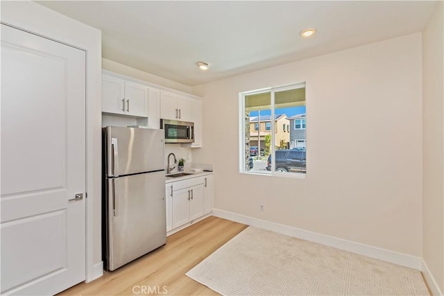 16707 Island Oak St, Fontana, CA 92336 - kitchen featuring stainless steel appliances, white cabinetry, light wood-style floors, recessed lighting, and light countertops