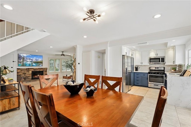 14 Black Oak, Irvine, CA 92604 - dining space featuring light tile patterned floors, stairs, a fireplace, ceiling fan, and a chandelier