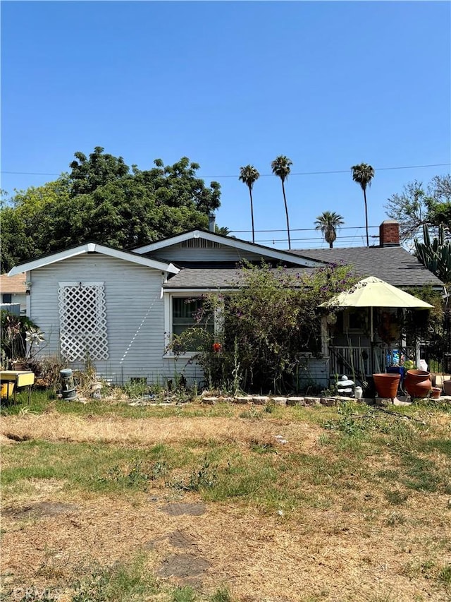 347 E 102nd St, Los Angeles, CA 90003 - rear view of property featuring a shingled roof and a chimney