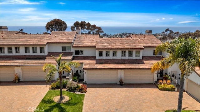 15 Vista Del Ponto Unit 70, San Clemente, CA 92672 - view of front of house featuring an attached garage, a chimney, stucco siding, and a tile roof