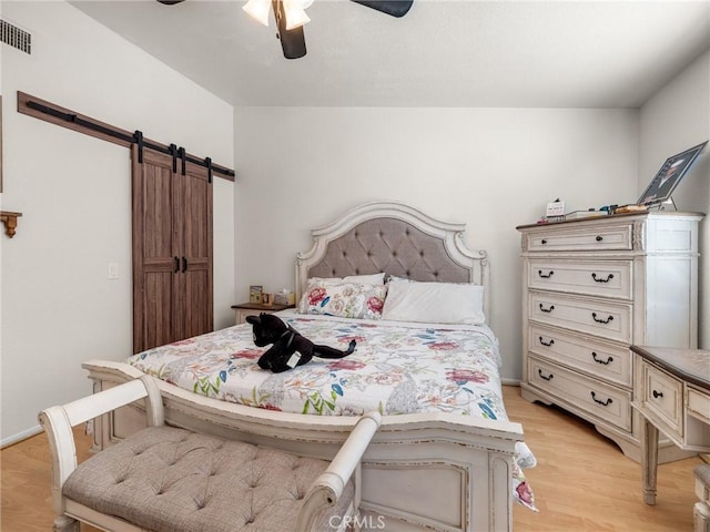 11671 Mountain Rd, Pinon Hills, CA 92372 - bedroom with a barn door, light wood-style floors, and ceiling fan