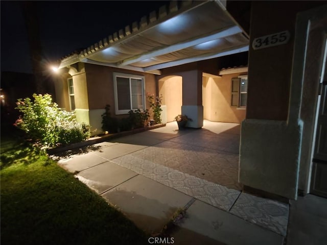 3455 Sugar Maple Ct, Hemet, CA 92545 - exterior entry at twilight with a patio and stucco siding