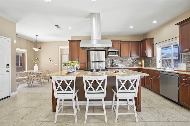 35887 Rhone Ln, Winchester, CA 92596 - kitchen featuring appliances with stainless steel finishes, island range hood, decorative backsplash, a center island, and light stone counters