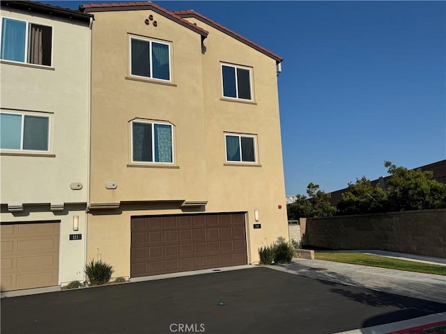 2750 W 182nd St Unit 112, Torrance, CA 90504 - rear view of house featuring stucco siding and a garage