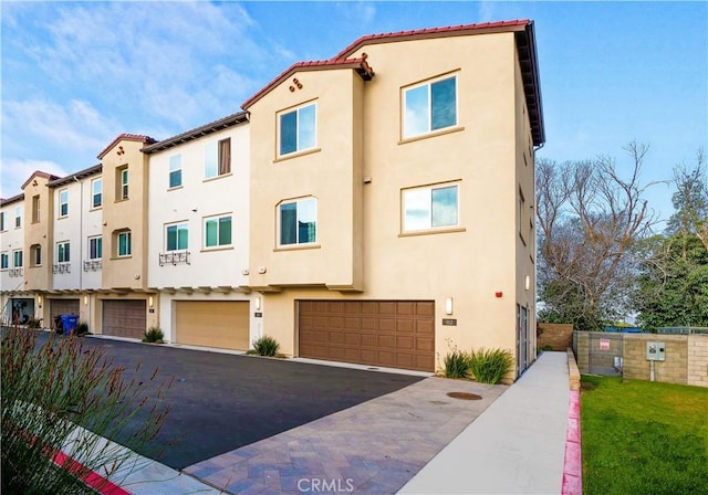 2750 W 182nd St Unit 112, Torrance, CA 90504 - view of property featuring stucco siding, a garage, driveway, and a tiled roof