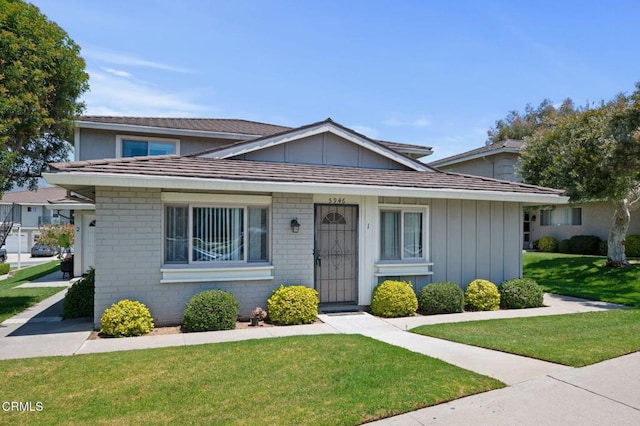 5946 Hickory St Unit 1, Carpinteria, CA 93013 - view of front of home with a front yard, board and batten siding, and brick siding