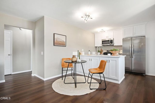 5946 Hickory St Unit 1, Carpinteria, CA 93013 - kitchen with stainless steel appliances, a peninsula, dark wood-type flooring, white cabinetry, and light countertops