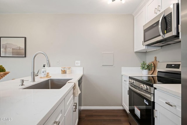 5946 Hickory St Unit 1, Carpinteria, CA 93013 - kitchen featuring stainless steel appliances, dark wood finished floors, white cabinets, and light stone countertops