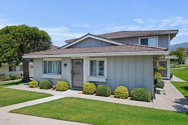 5946 Hickory St Unit 1, Carpinteria, CA 93013 - view of front of house with board and batten siding and a front yard