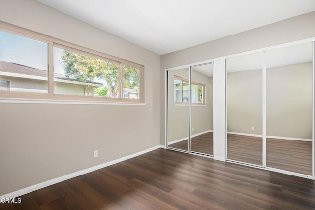 5946 Hickory St Unit 1, Carpinteria, CA 93013 - unfurnished bedroom featuring multiple closets and wood finished floors