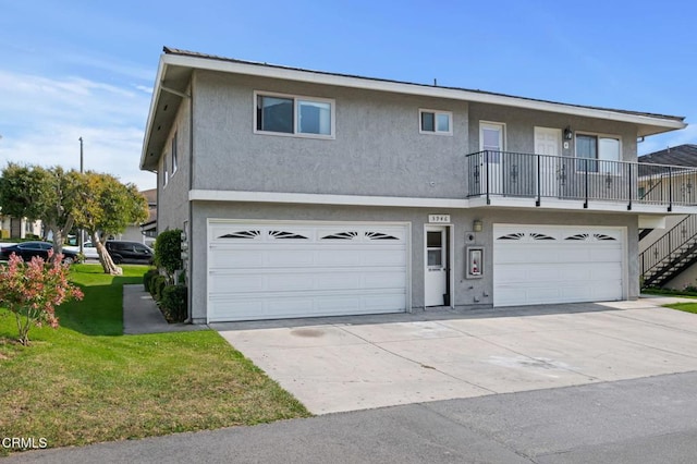 5946 Hickory St Unit 1, Carpinteria, CA 93013 - view of front of property featuring an attached garage, stucco siding, a front lawn, driveway, and stairway