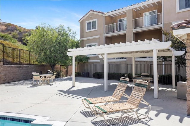 2802 Green River Rd Unit 101, Corona, CA 92882 - back of property featuring a pergola, stucco siding, a patio area, a fenced backyard, and a balcony