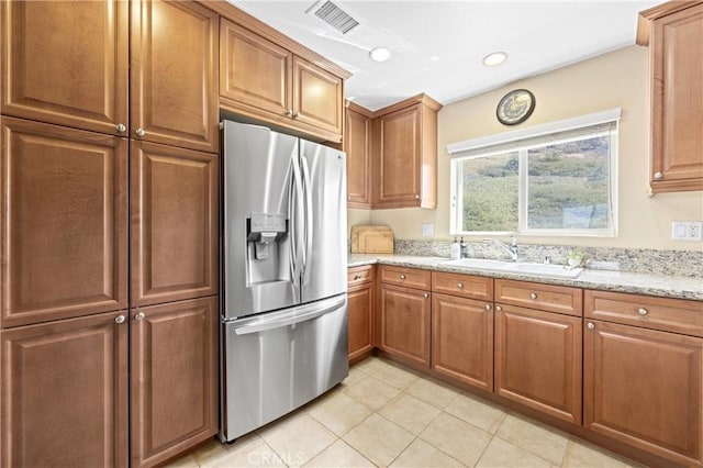2802 Green River Rd Unit 101, Corona, CA 92882 - kitchen featuring stainless steel fridge, light tile patterned floors, light stone counters, brown cabinetry, and recessed lighting