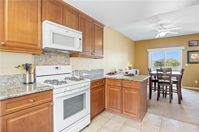 2802 Green River Rd Unit 101, Corona, CA 92882 - kitchen with white appliances, a peninsula, a ceiling fan, and brown cabinetry