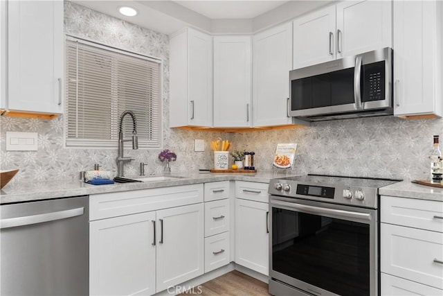 1837 N Studebaker Rd, Long Beach, CA 90815 - kitchen featuring appliances with stainless steel finishes, white cabinets, and tasteful backsplash