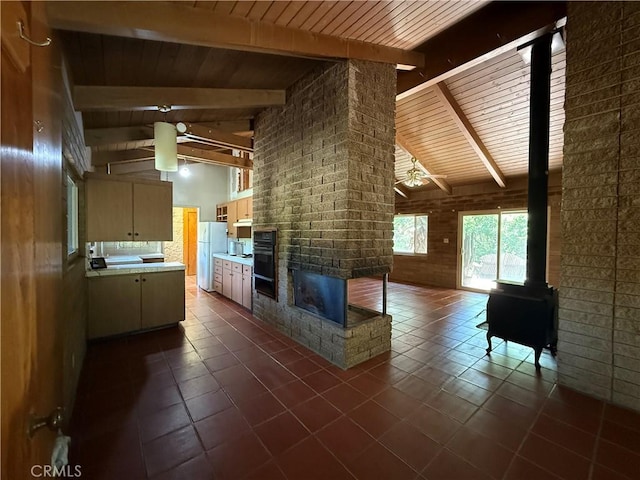 11955 Santa Lucia Rd, Atascadero, CA 93422 - living room with a wood ceiling with exposed beams, ceiling fan, a wood stove, a fireplace, and dark tile patterned flooring